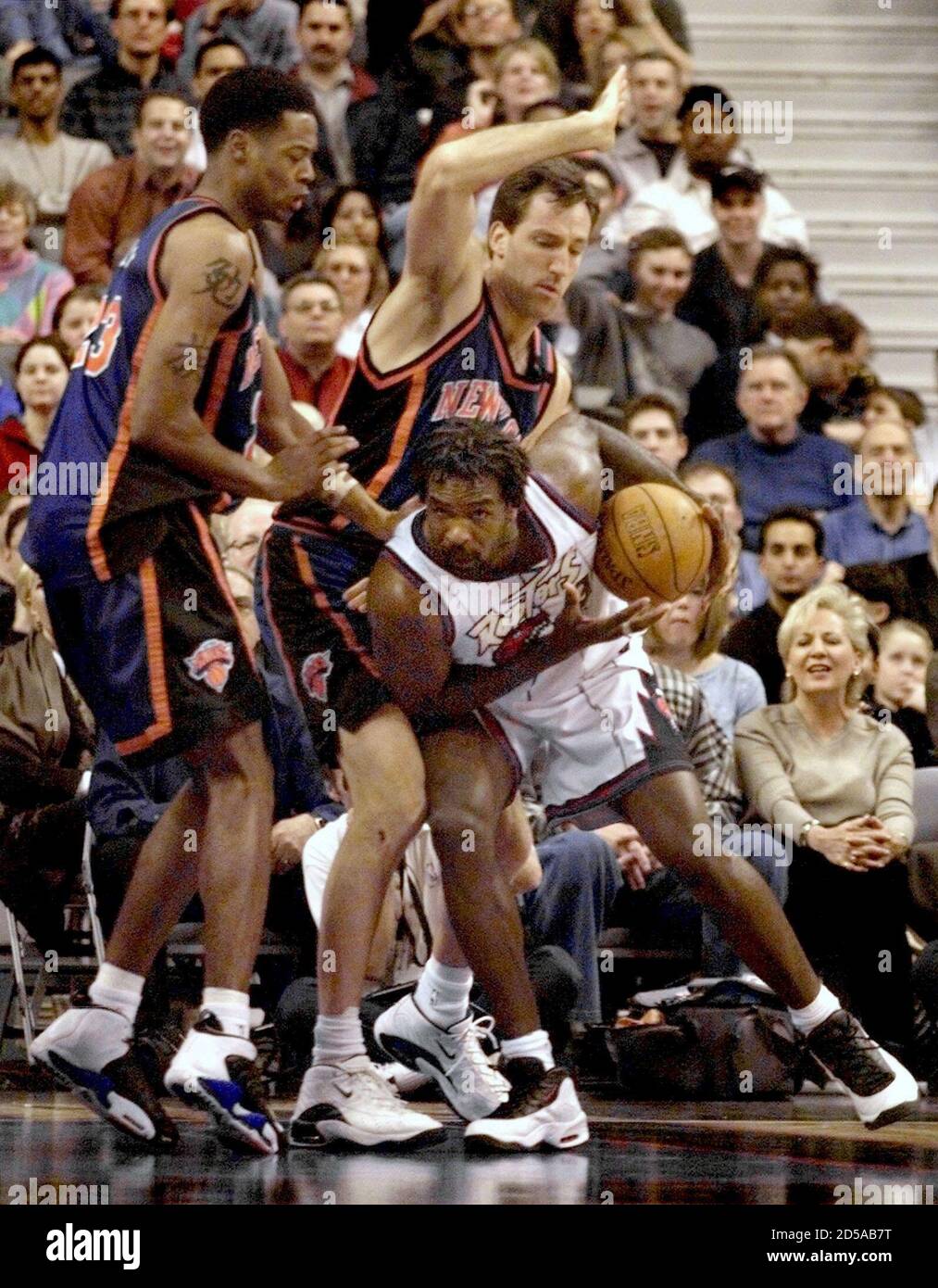 Toronto Raptors forward Charles Oakley (R) fights for position under the  basket against New York Knicks forward Marcus Camby (L) and center Chris  Dudley during first half NBA action at the Air