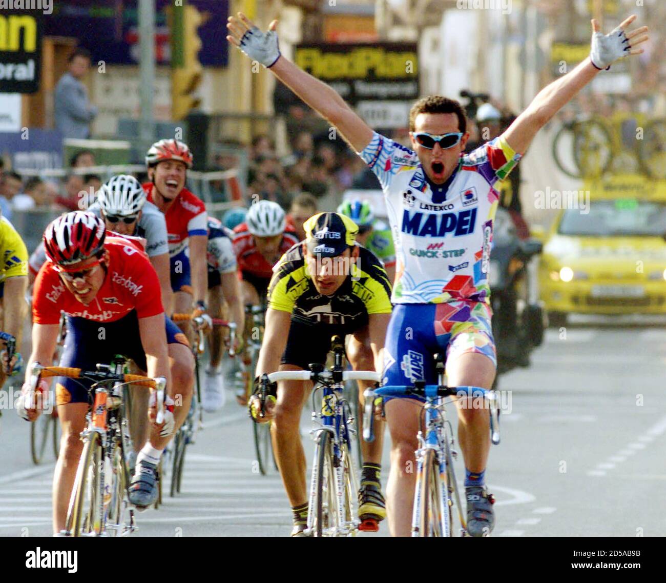 Italian rider Giuliano Figueras raises his arms as he crosses the finish  line to win the fourth stage of the Catalan cycling week March 25. Behind  Figueras are third-placed Niki Aebersold of