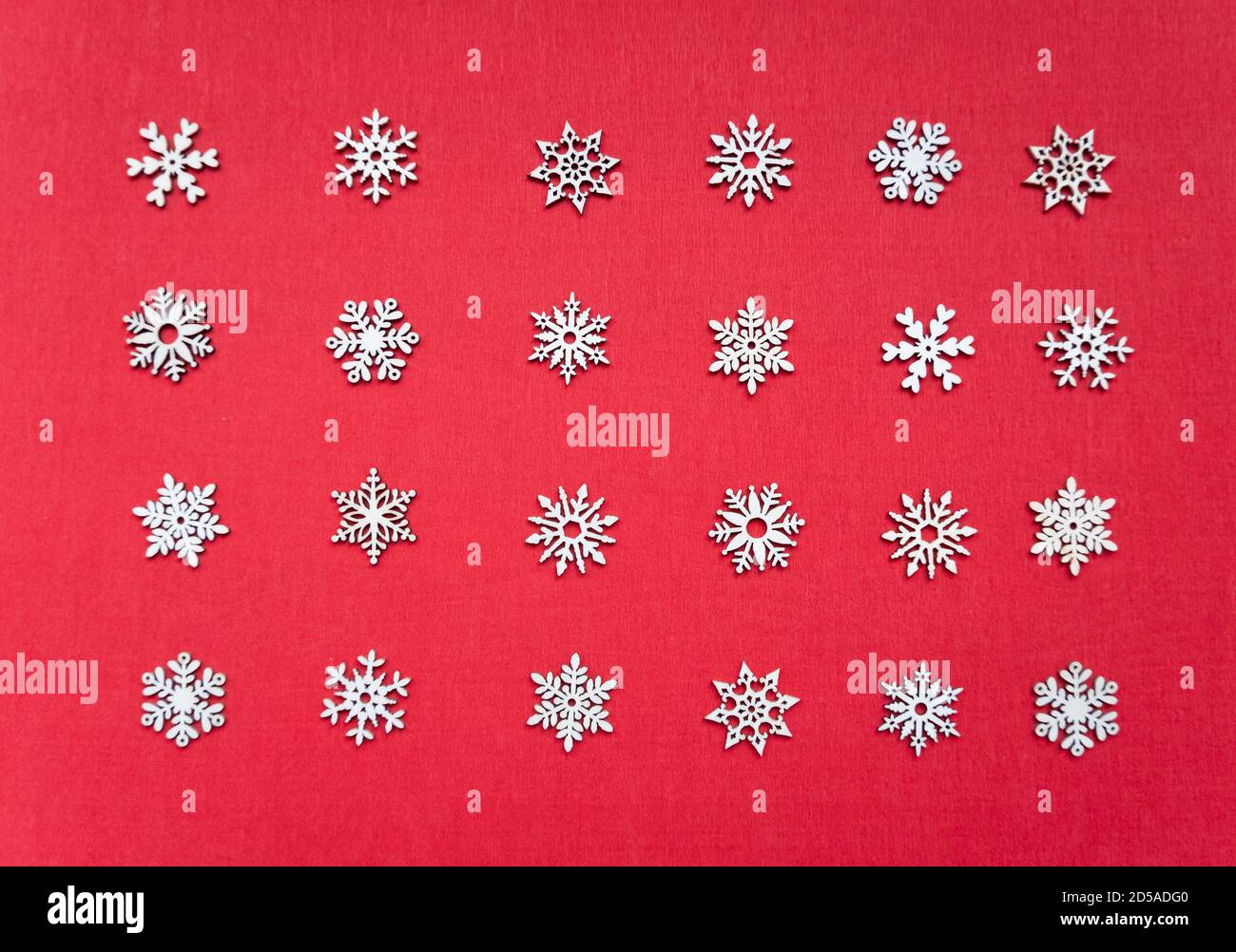 Decorative white Christmas snowflakes non-repeat ornament in geometrical order on the red textured background, simple abstract texture Stock Photo