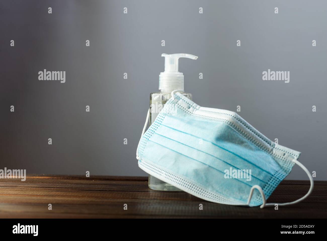 Medical face mask with alcohol sanitizer gel hand wash on wood table for covid-19 Stock Photo