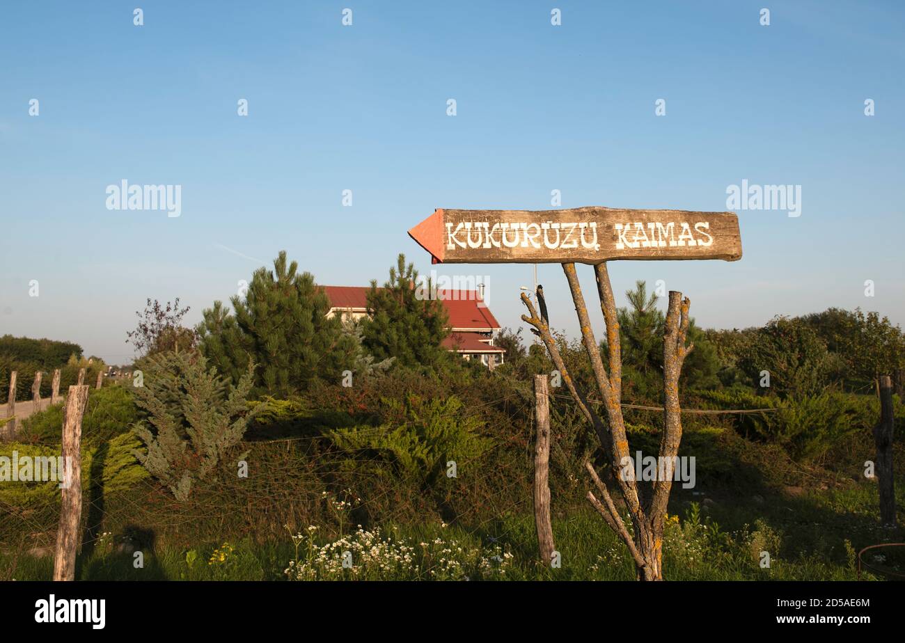 Information sign, direction sign to Corn village in Lithuania, Vilnius suburb. Welcome to Corn village.Interesting leisure park near Vilnius Stock Photo