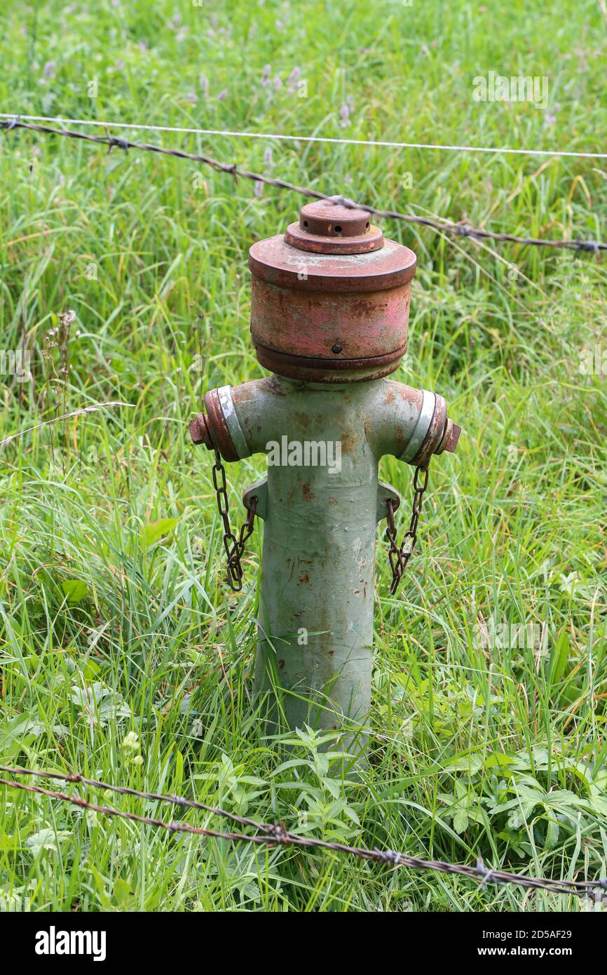 Vertical shot of an old hydrant stands on the street Stock Photo