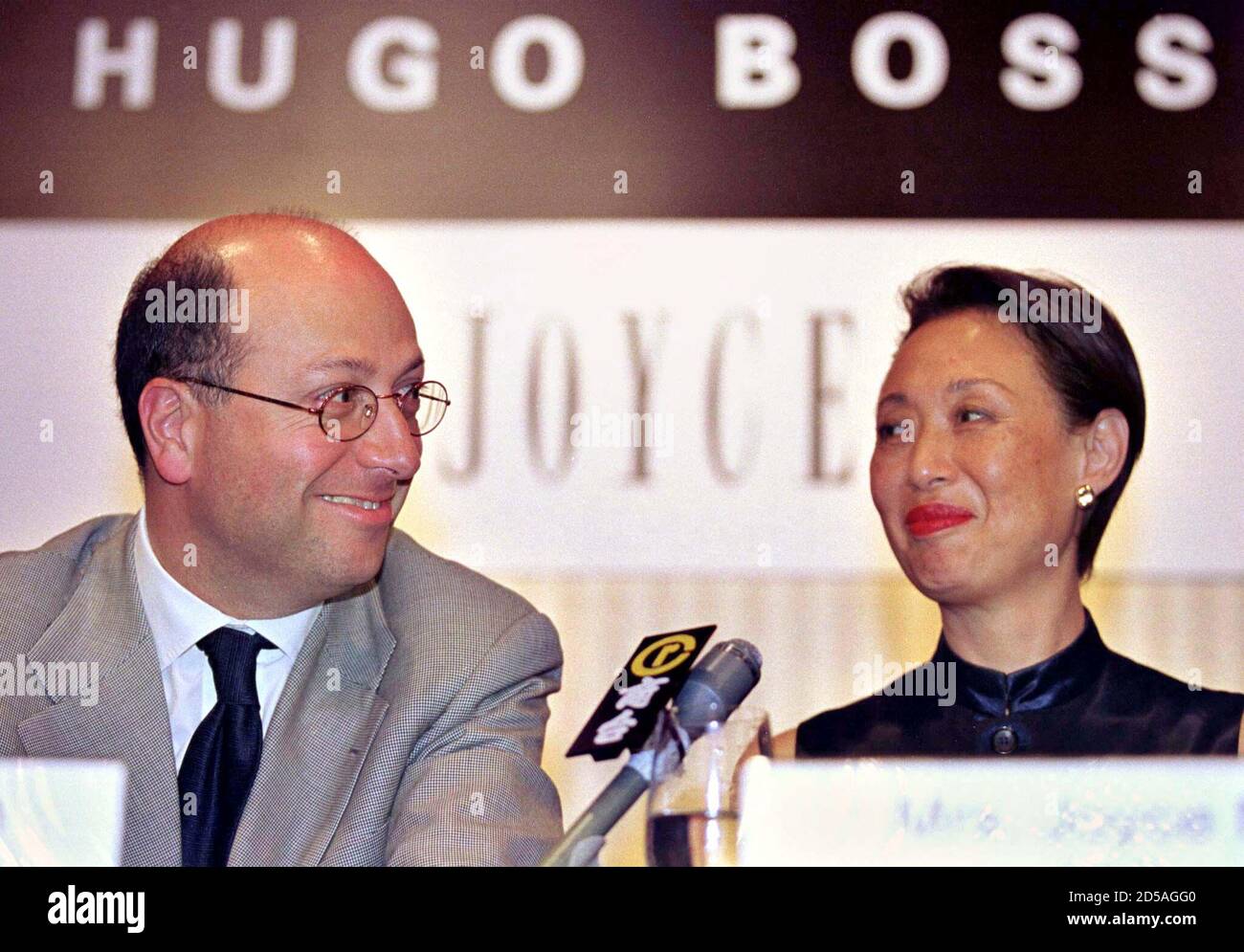 Peter Littmann (L), president and chief executive officer of German  menswear company Hugo Boss, and Joyce Ma, founder of Hong Kong fashion  retailer Joyce Boutique, smile at each other as they take