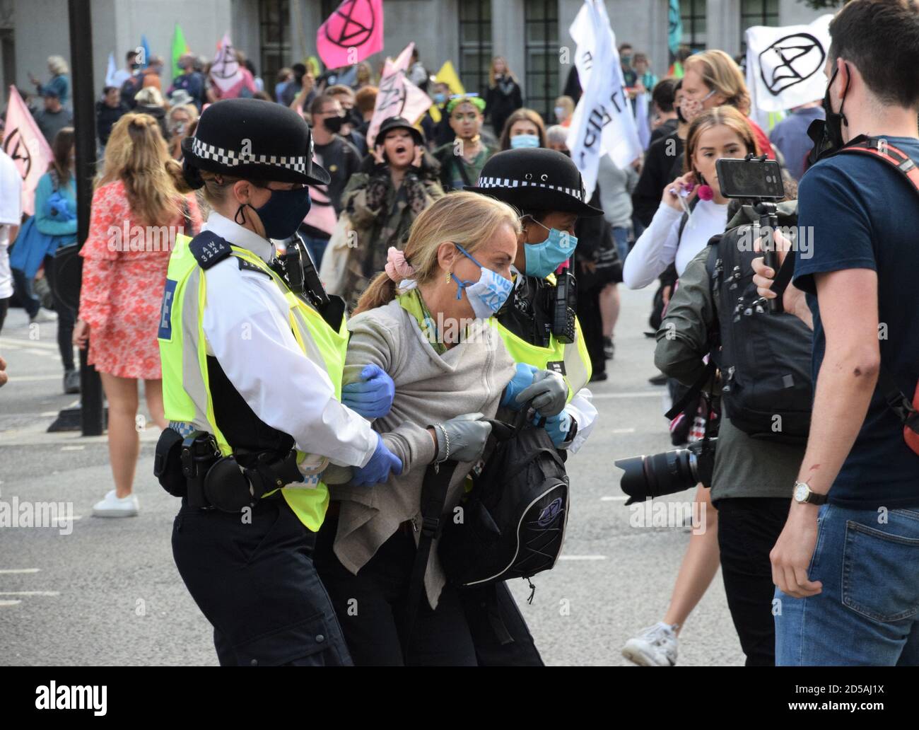 Police with protective face masks arrest a demonstrator at the Extinction Rebellion climate change and animal agriculture protest at Parliament Square, London, September 2020 Stock Photo