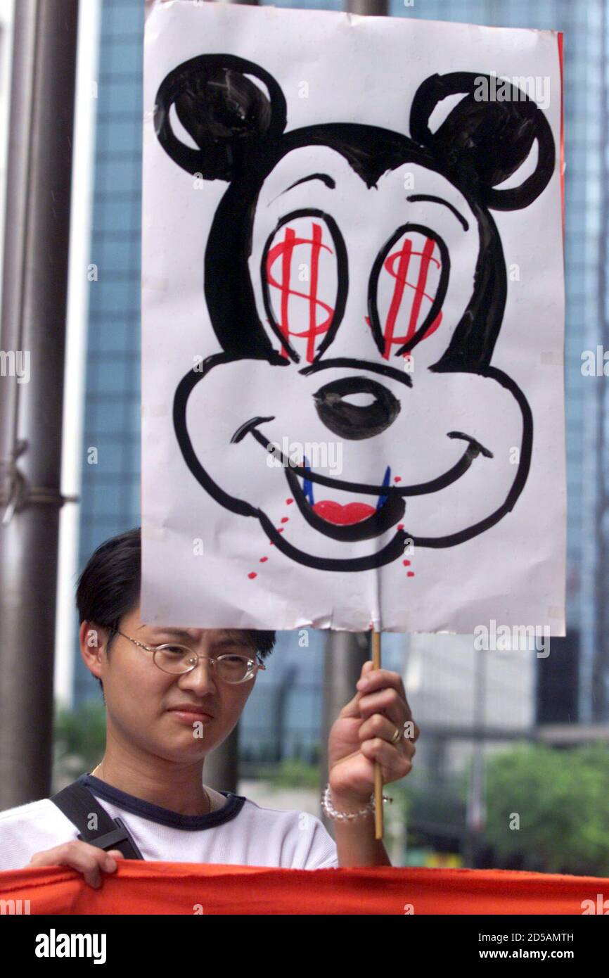 A protester holds a placard with a drawing of Mickey Mouse outside the Hong Kong Convention and Exhibition Centre where a Disney consumer products exhibition is held August 5. Protesters are accusing Disney product manufacturers of cheap labour practices. The Hong Kong government injected a note of optimism into the territory's gloomy economy as talks are underway with Walt Disney on the prospect of building a Disney theme park in the territory.  BY/CC/JRE Stock Photo