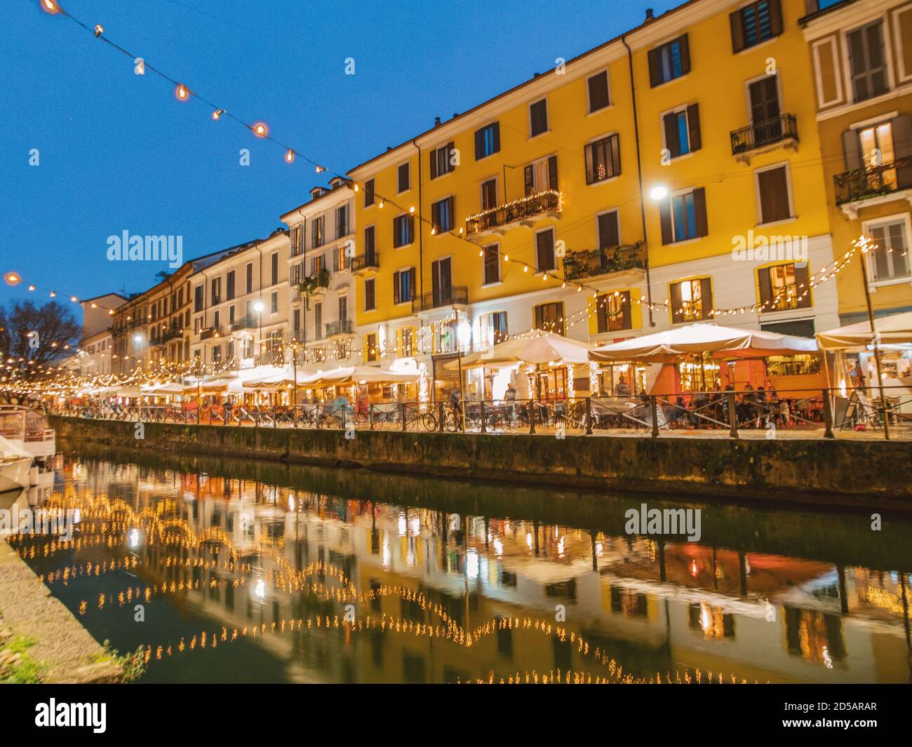 It's Christmas time on the 'Navigli' with thousands of lights reflected in the canal of the famous tourist district in December. Milan, Lombardy, Ital Stock Photo