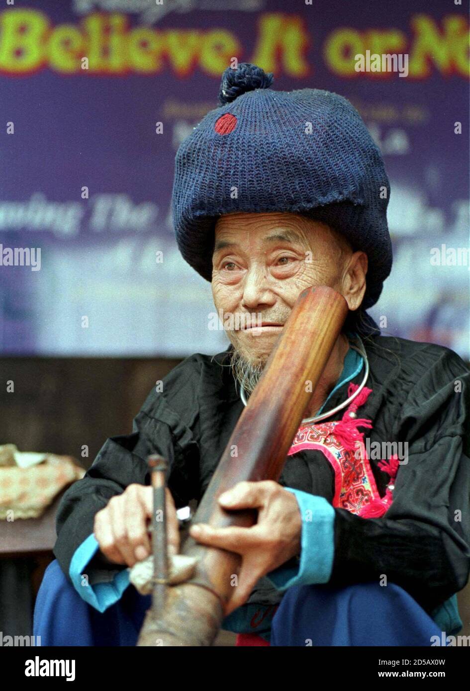 Lu Seng La, a 77-year-old Hmong hilltribe man, wears a hat to protect his  locks tidily wrapped as he enjoys a pipe of opium at home in his hut in  Chiang Mai