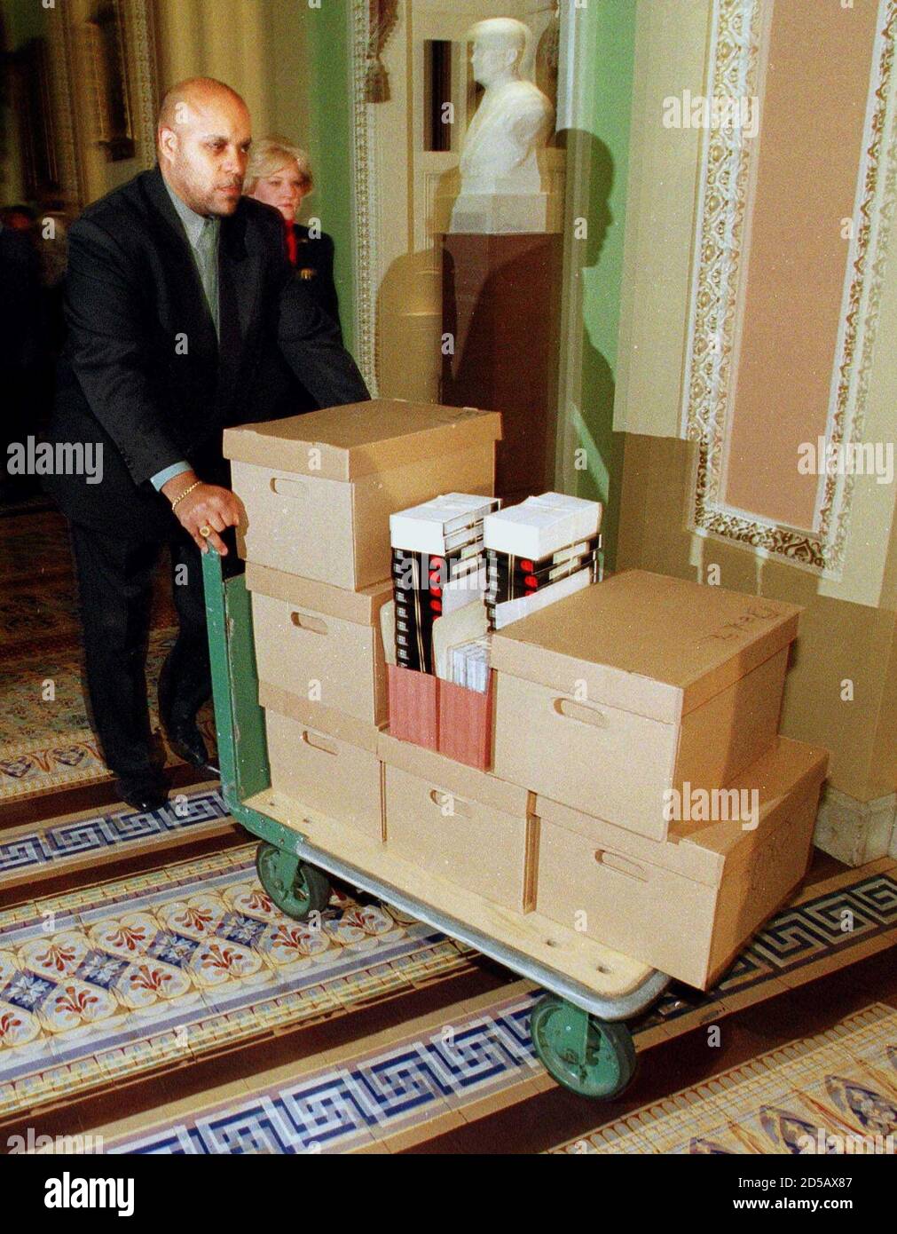 A Capitol Hill staff member delivers evidence in the impeachment trial against U.S. President Bill Clinton to Senators offices in the Capitol from the House Judicary Committtee, January 13. Each Senator got three and half boxes full of information for their consideration in the president's pending trial.  JP/SV/JDP Stock Photo