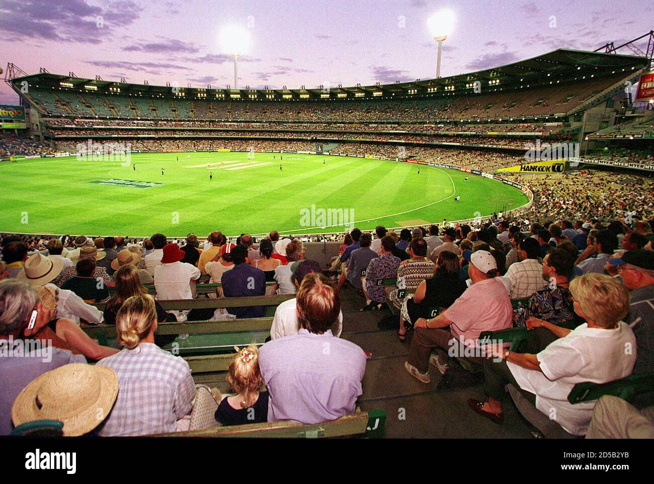 Spectators At The Melbourne Cricket Ground Mcg Watch A Day Night Cricket Match Under Lights With The Stadium S Southern Stand In The Background The Mcg Will Be A Venue For Soccer Matches During