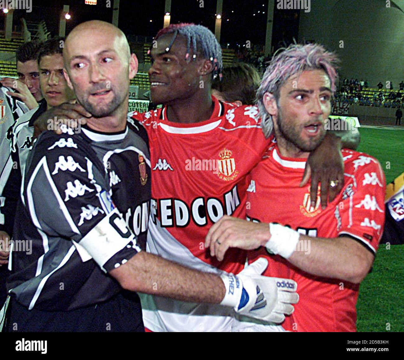 Italy's Marco Simone (R) Martin Djetou (C) and captain and goalkeeper  Fabien Barthez (L) of Monaco celebrate their French champion title  following the match against Le Havre, in Monaco May 4. Simone