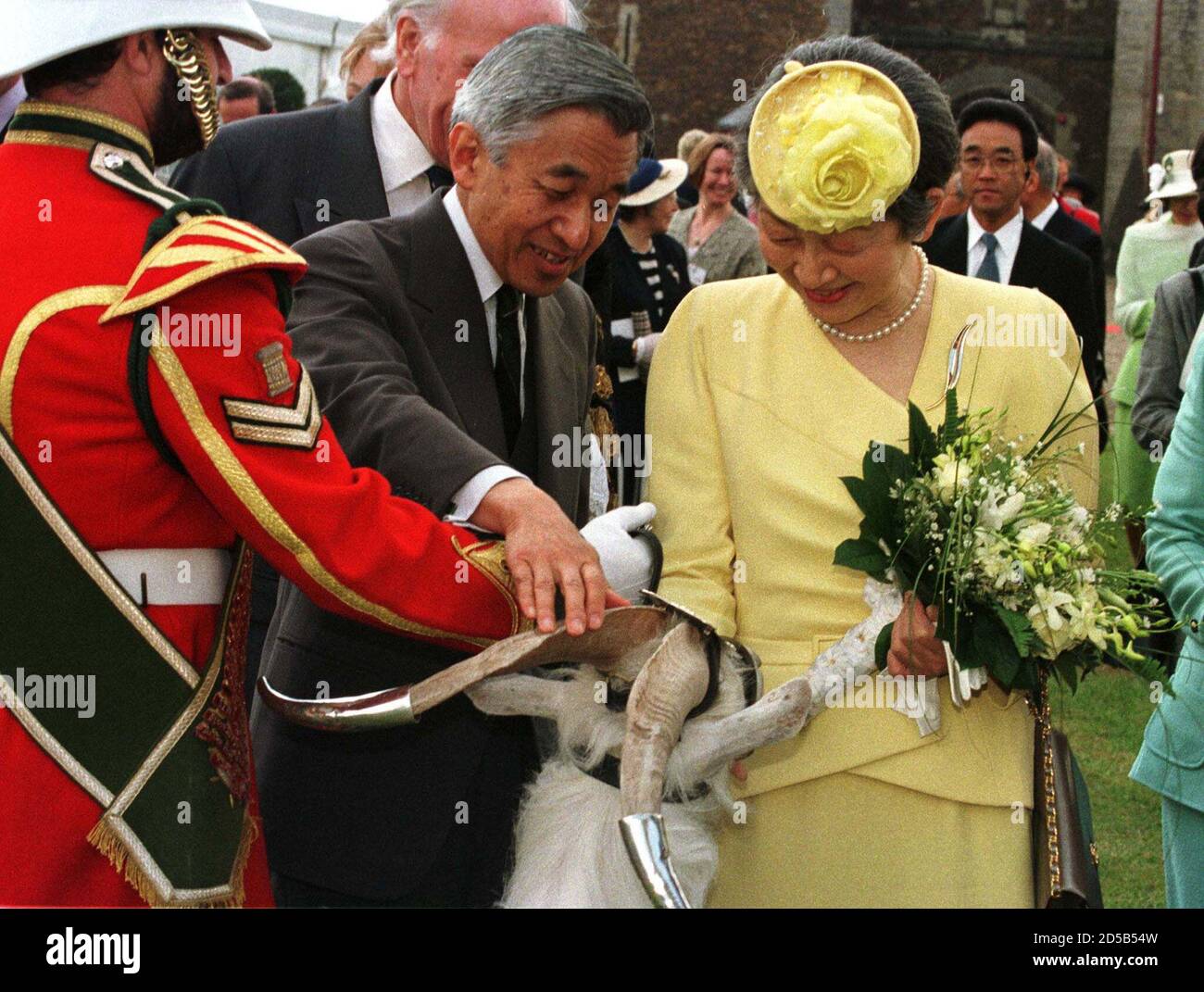Japanese Emperor Akihito (C) and Empress Michiko meet Shenkin, a 22-month-old Royal Windsor White Goat who is the Regimental mascot for the 2nd Battalion of the Royal Regiment of Wales, during their visit to Cardiff Castle in Wales May 27. The Emperor's visit has sparked controversy among former Japanese Prisoners of War who are demanding an apology and compensation for the treatment they received at the hands of the Japanese during World War II.  SR/EB Stock Photo