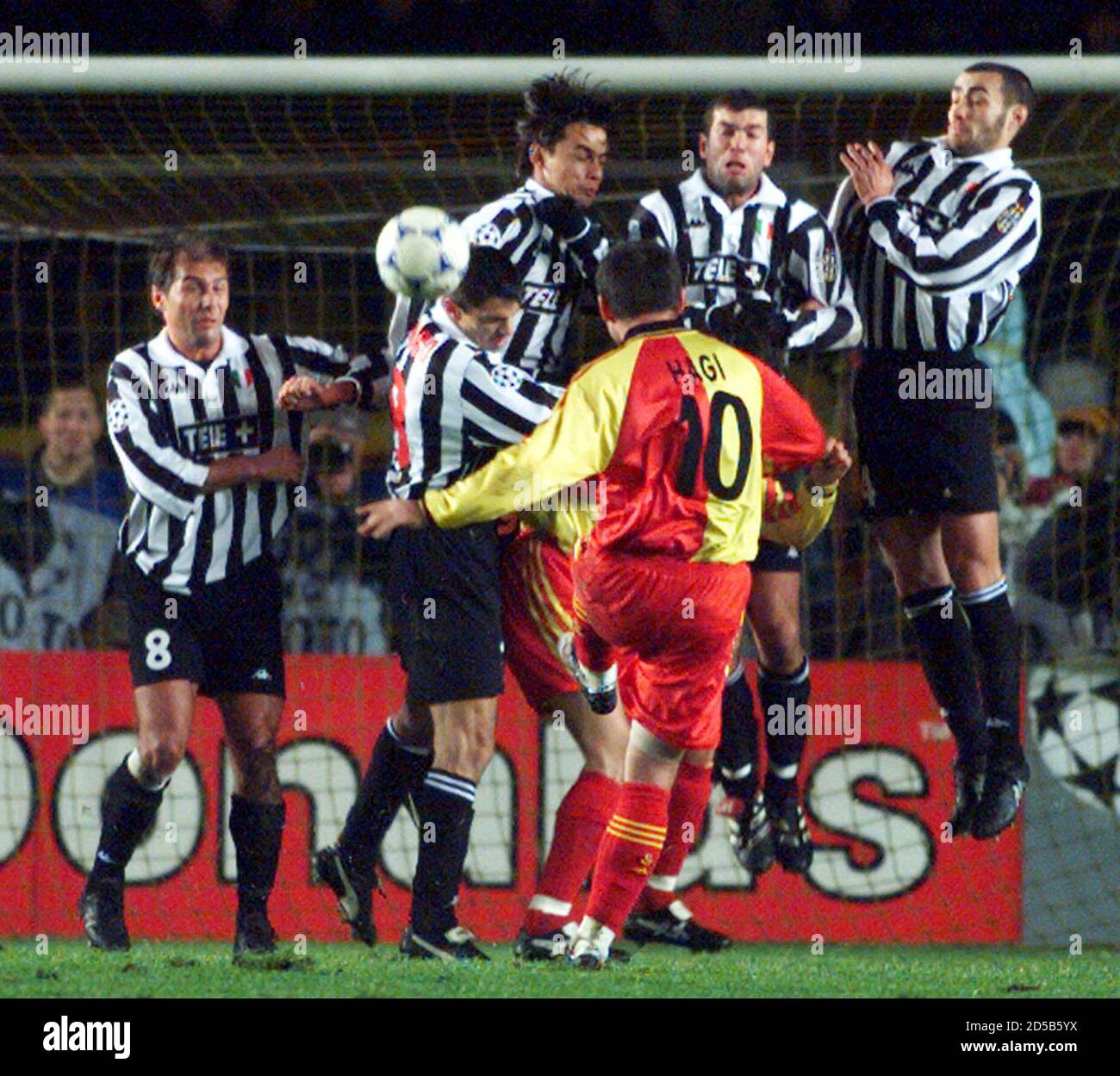 Galatasaray's Romanian international Gheorghe Hagi (10) hits a free-kick as Juventus players jump at the ball during their delayed Champions' League match in Istanbul December 2. The Juventus players (L-R) are, Antonio