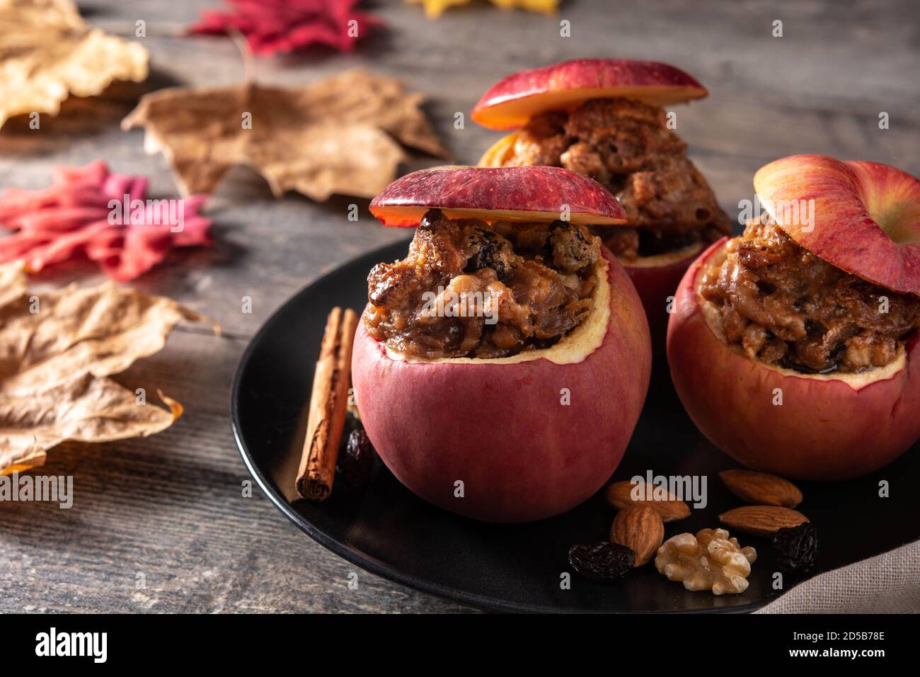 Stuffed apples baked with nuts on wooden table Stock Photo