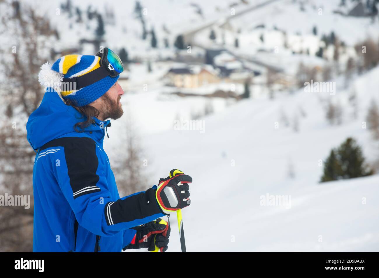 Close up portrait of man skier in hat and ski goggles mask looking at mountain range Col Gallina Cortina d'Ampezzo Dolomites Stock Photo