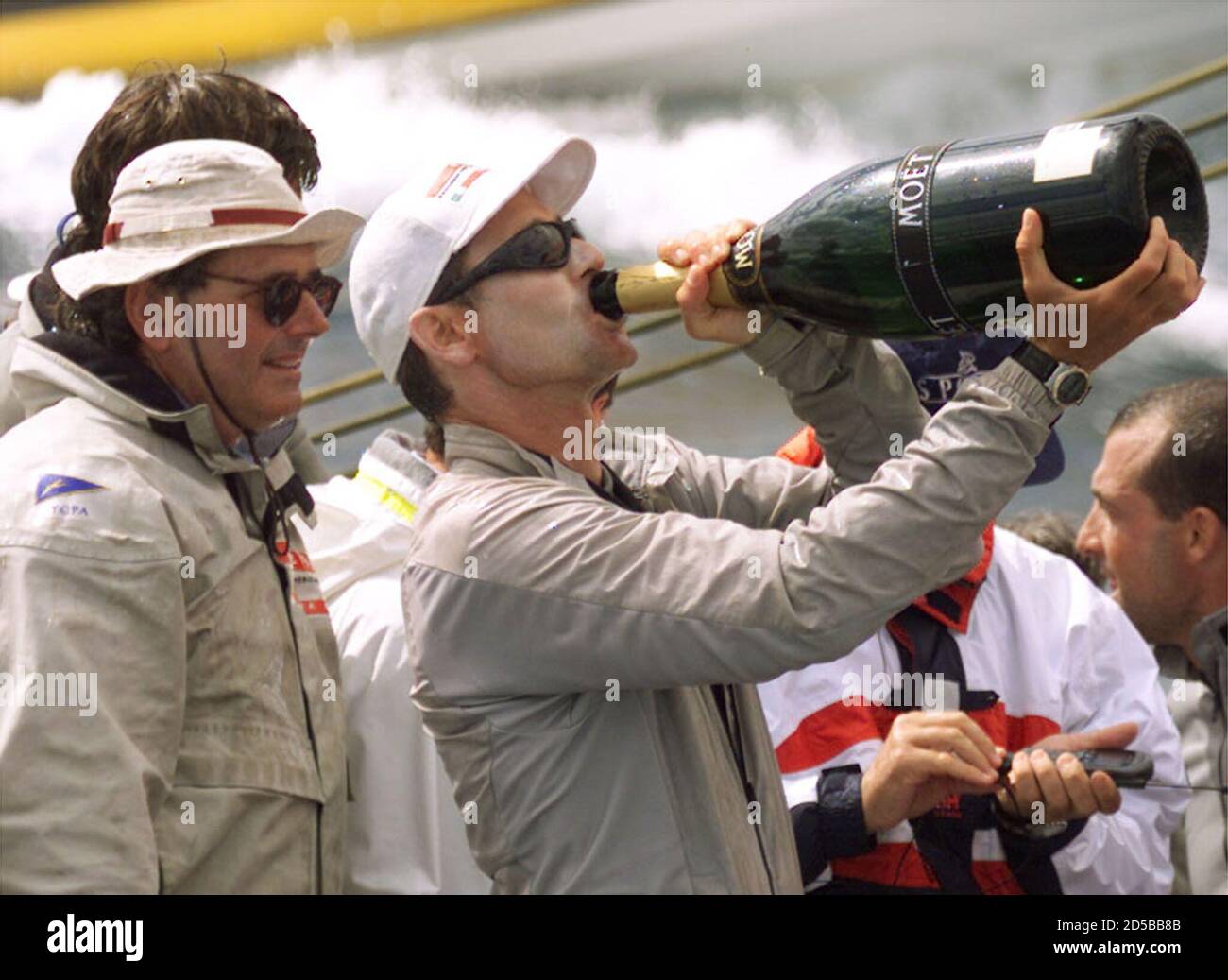 The skipper of Italian yacht Prada Francesco de Angelis (R) drinks  champagne after he and his crew defeated AmericaOne to win the final race  of the Louis Vuitton Cup finals on the