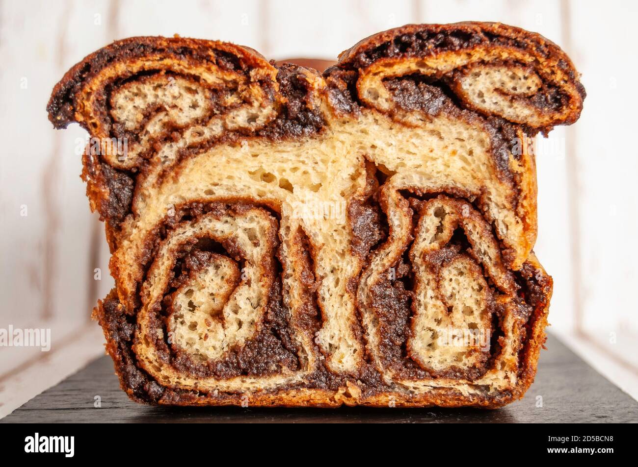 Cocoa and nuts sweet bread on black plate, front view Stock Photo