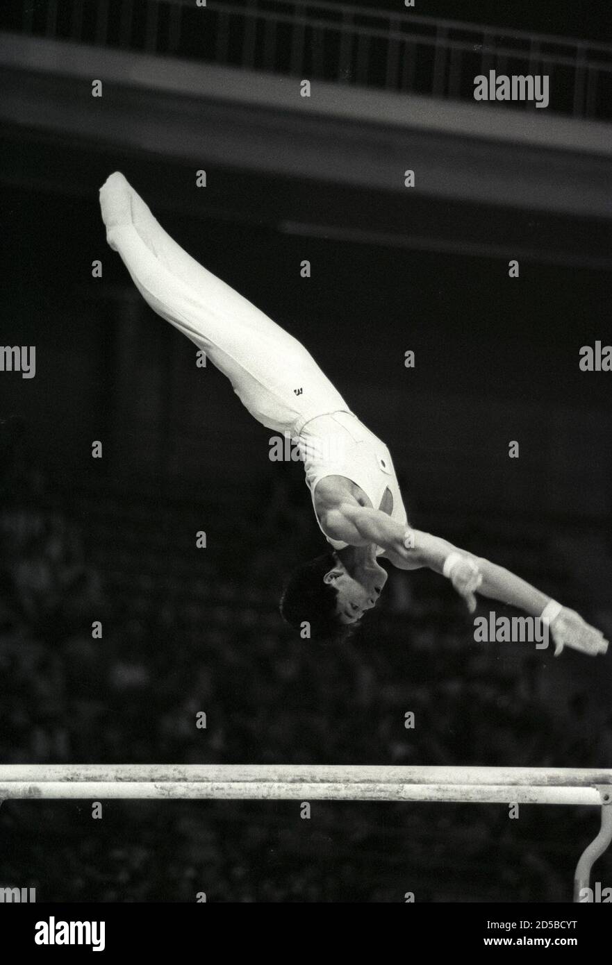 Koichi Mizushima of Japan executes a backflip over the parallel bars as he dismounts at the end of his routine during the men's team competition during the 1986 Asian Games in Seoul September 21, 1986. SCANNED FROM NEGATIVE. REUTERS/Shunsuke Akatsuka  GDB/CMC/PN Stock Photo