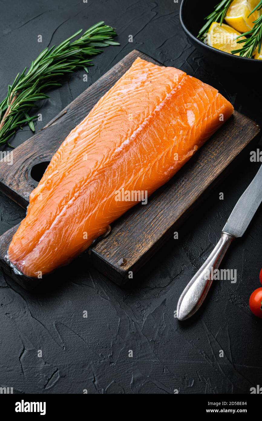 Whole raw salmon fillet on black background Stock Photo - Alamy