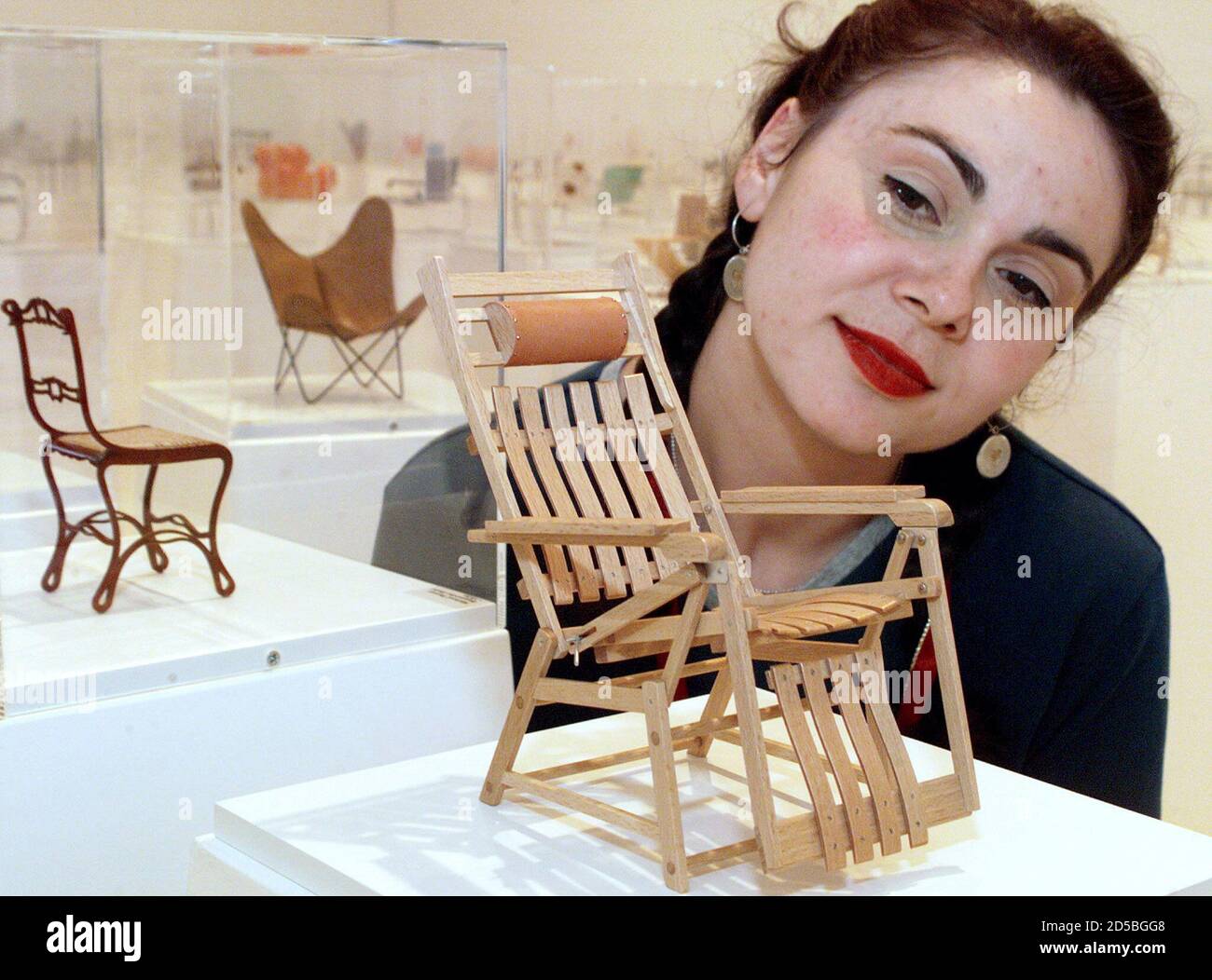 Melbourne gallery administrator Deonisia  Soundias looks at a miniature model of a wooden chair, the 'Siesta Medizinal' on display at the Royal Melbourne Institute of Technology (RMIT) Gallery April 21. The chair, designed and built in 1936 by Hans and Wassily Luckhardt of Germany,  joins 99 others in the Dimensions of Design - 100 Classic Seats exhibition. The miniature reproductions, true to the workmanship, detail and materials of the original, are on a national tour. **DIGITAL IMAGE** Stock Photo
