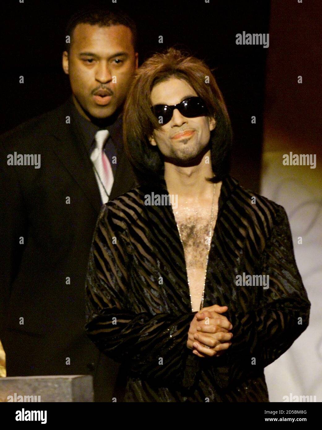 'The Artist' formerly known as Prince, accompanied by his bodyguard, listens to the applause of the crowd after being named Male Artist of the Decade at the 14th annual Soul Train Music Awards March 4.  GMH Stock Photo