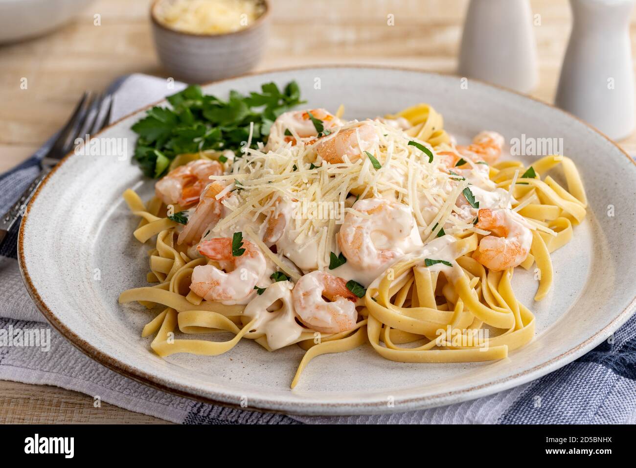 Creamy fettuccine alfredo with shrimp and shredded parmesan cheese on a