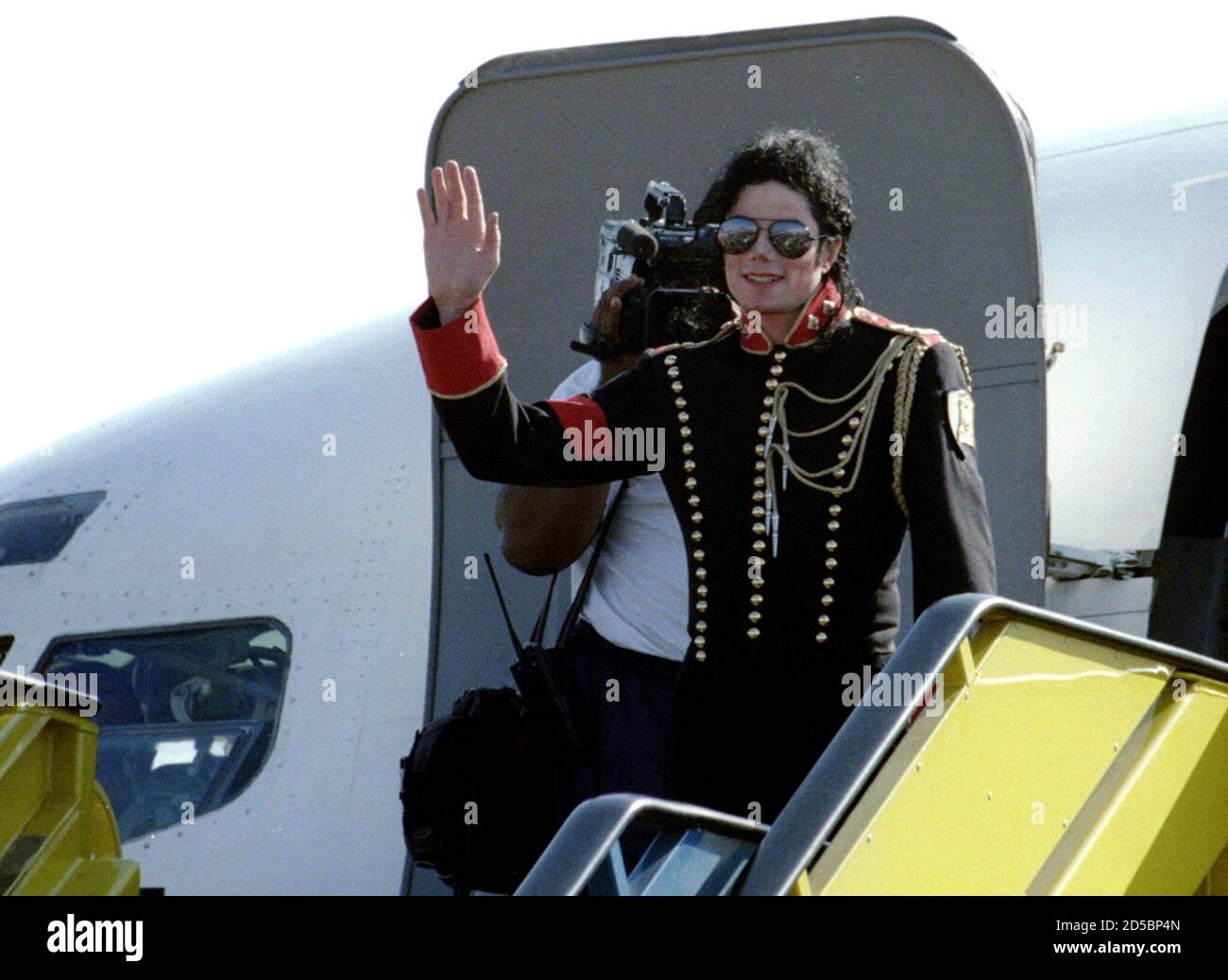 American pop star Michael Jackson waves to fans from his private aircraft as he arrives at Johannesburg International airport July 18. Jackson who is not due to give any concerts in South Africa, is on a three-day visit sponsored by an unlikely coalition of big business and radical black politicians. Stock Photo