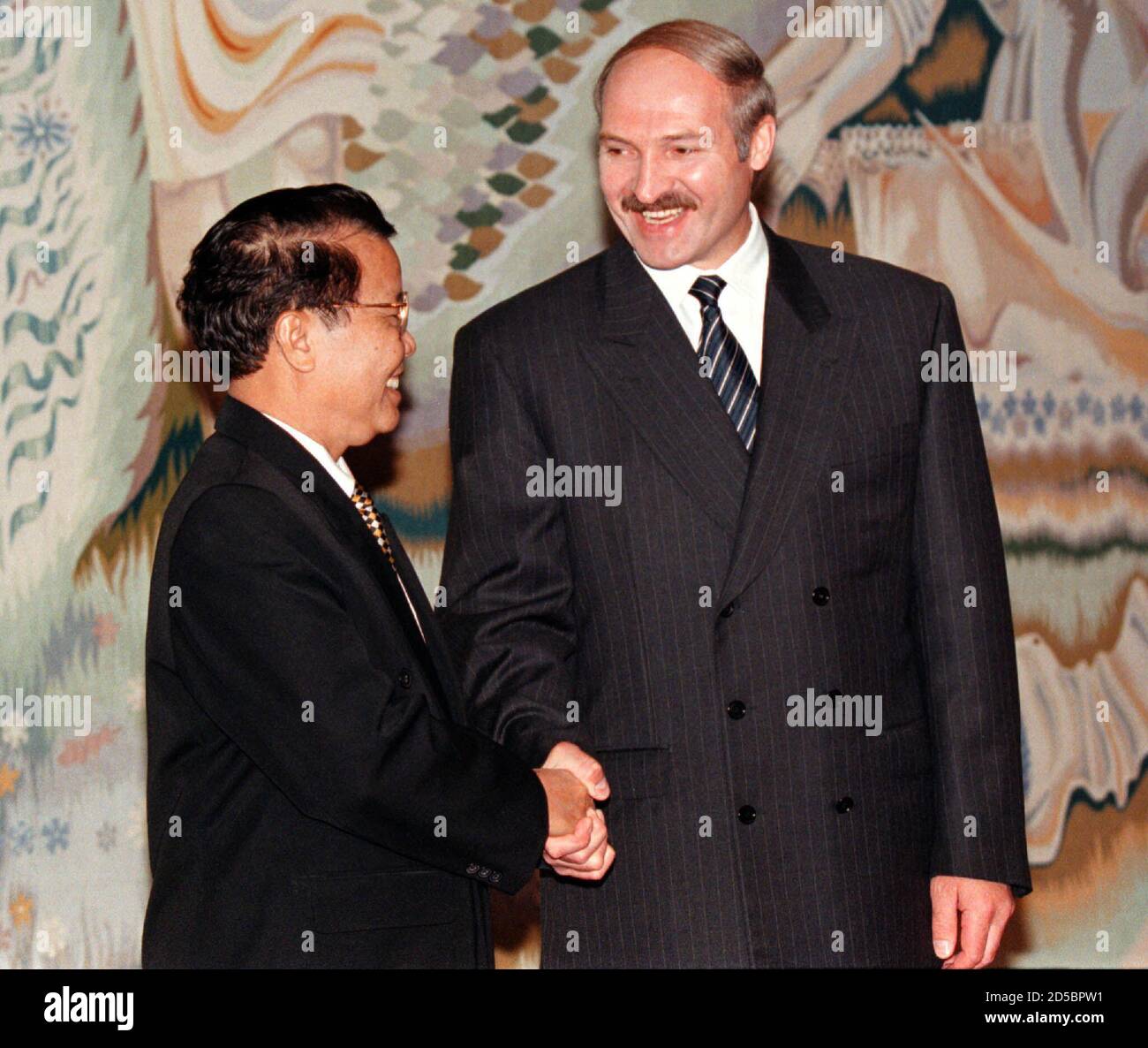 Belarussian President Alexander Lukashenko (R) shakes hands with his 