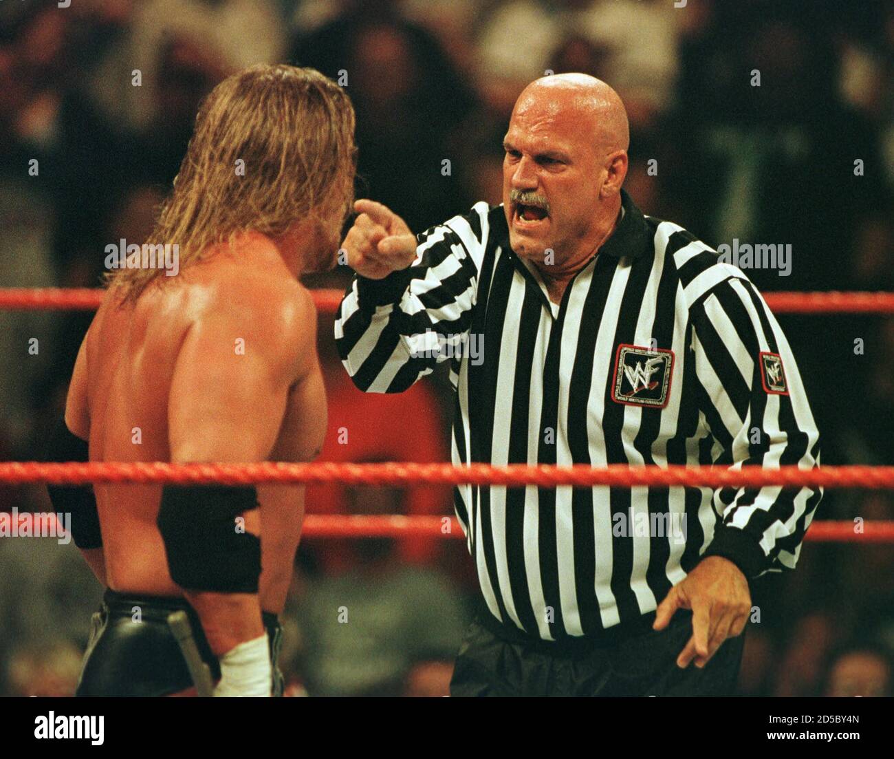 Minnesota Governor Jesse Ventura (R) argues with wrestler "Triple H" as he  referees the championship match of the World Wrestling Federation's (WWF)  SummerSlam event at Target Center in Minneapolis, August 22. Jesse "