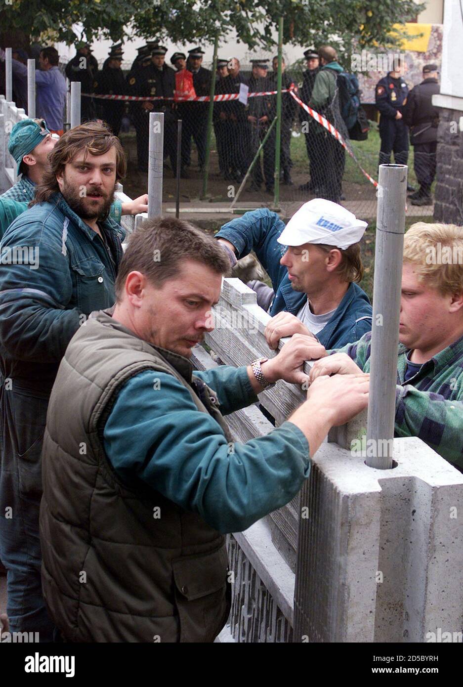 Workers, protected by several dozens of policemen (background) build the  controversial fence in Maticni Street of the north bohemian town of Usti  nad Labem, October 13. The wall is supposed to divide