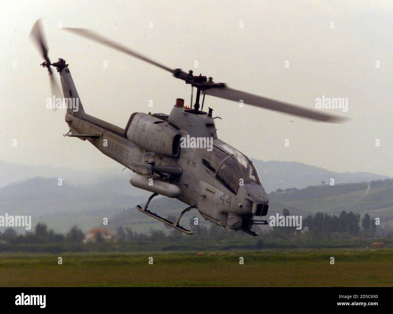 EDITORIAL USE ONLY - NO COMMERCIAL OR BOOK SALES. A U.S. Marines AH-1W Super Cobra gunship flies low over Albania May 9. The Aviation Combat Element (ACE) for the 26th Marine Expeditionary Unit (MEU) includes 12 CH-46E Sea Knight transport chopers, four CH-53E Super Stallion heavy-lift chopers, four AH-1W Super Cobra gunships, two UH-1N utility chopers and six AV-8B Harrier attack jets. **DIGITAL IMAGE** Stock Photo