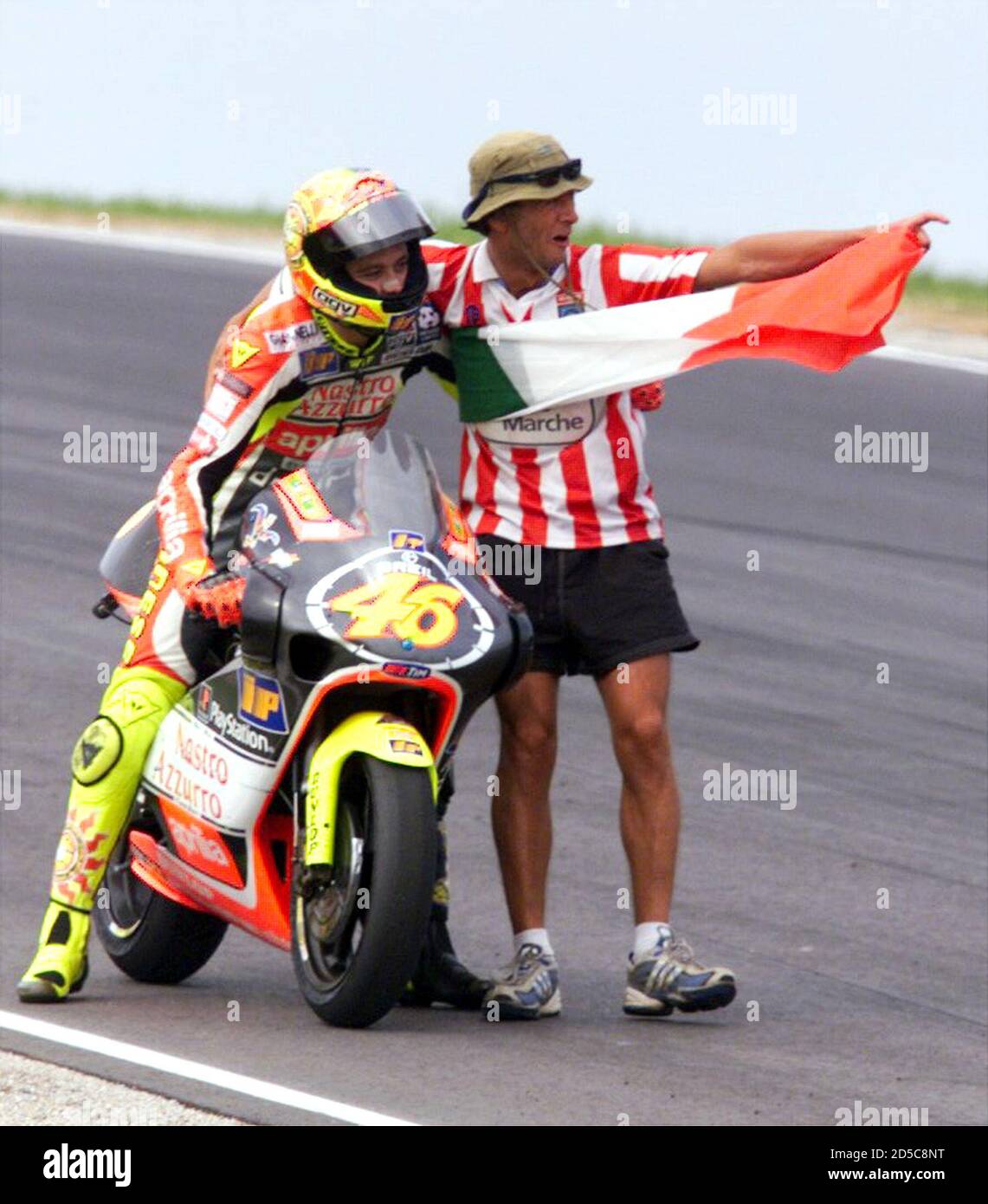 Valentino Rossi of Italy directions and an Italian flag from an enthusiastic spectator after winning the Australian 250 cc Motrorcycle Grand Prix at Phillip Island October 3. Second was Olivier Jacque