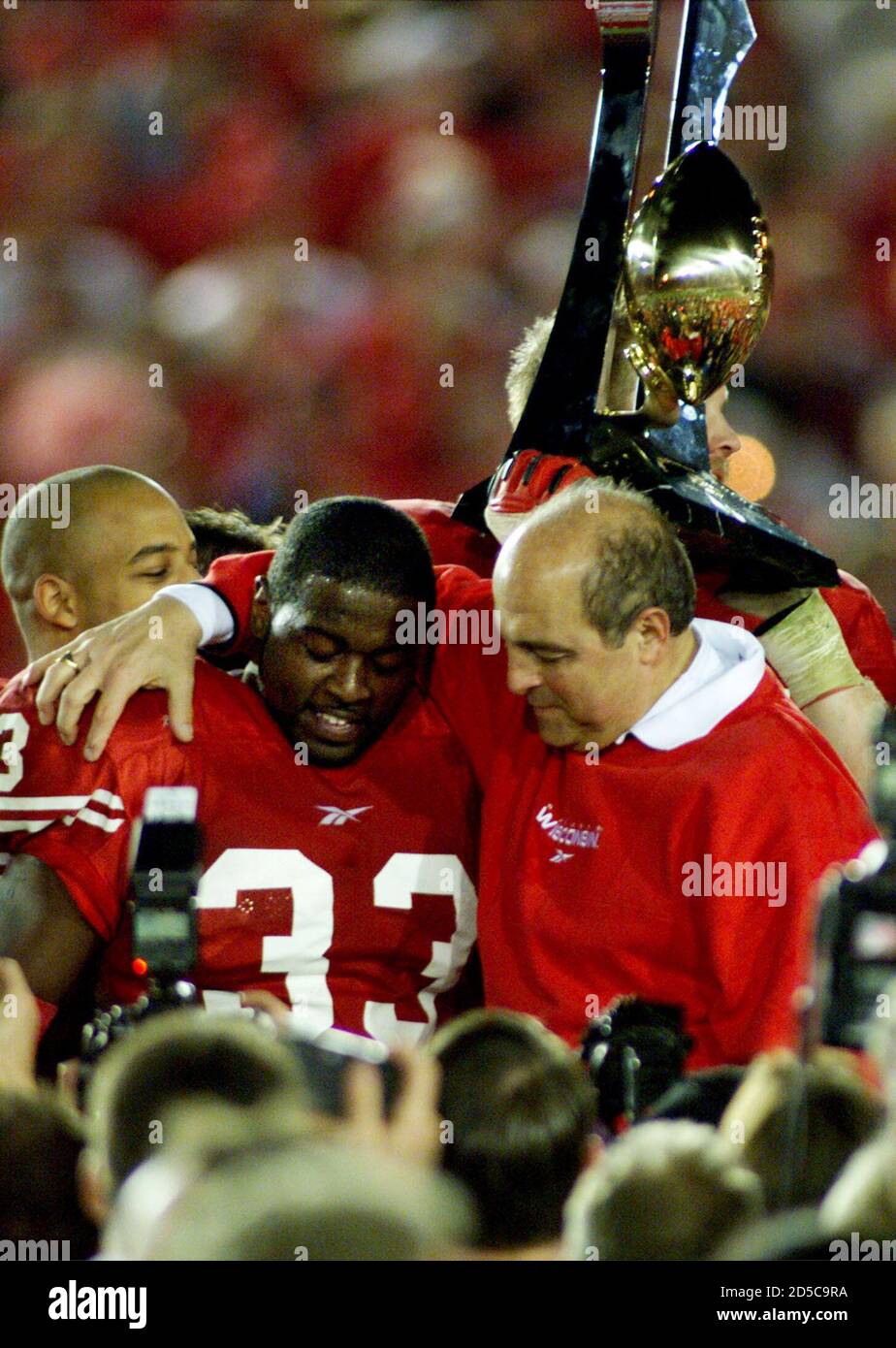 Wisconsin tailback Ron Dayne (L) and head coach Barry Alvarez hug next to  the Rose Bowl trophy after beating Stanford 17-9 at the 86th Annual Rose  Bowl January 1 in Pasadena. Dayne