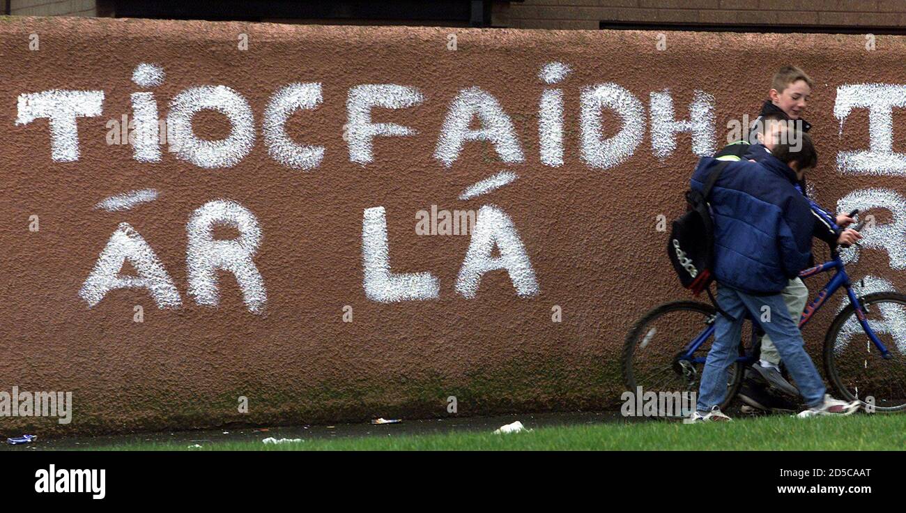 Young boys pass a wall bearing the Irish Republican Army (IRA) graffitti in  Irish meaning "Our Day Will Come" in Poleglass, west Belfast February 26.  Chief of Defence Staff Sir Charles Guthrie