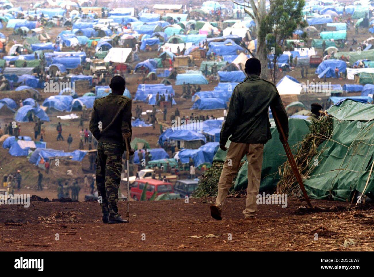 Two wounded Rwandan soldiers limp 23 August as they approach the Panzi refugee camp which houses some 10,000 ex-Rwandan soldiers and their families. The residents of the camp complain of not receiving enough food and humanitarian assistance Stock Photo