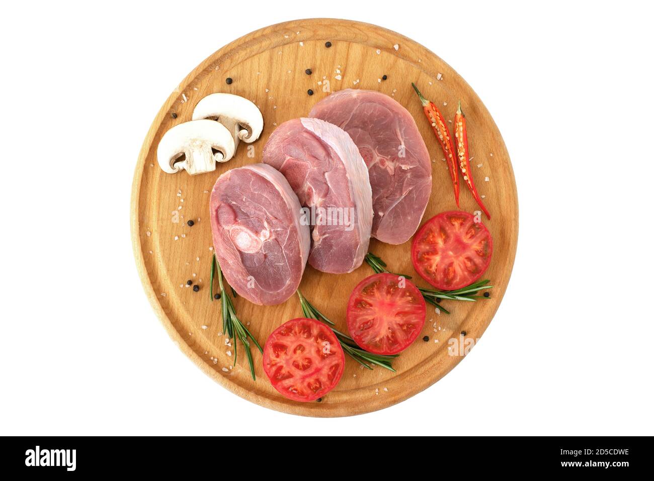 pieces of raw turkey meat, chopped leg steak, portioned barbecue pieces, on wooden board with rosemary, tomatoes and red hot pepper. isolate Stock Photo