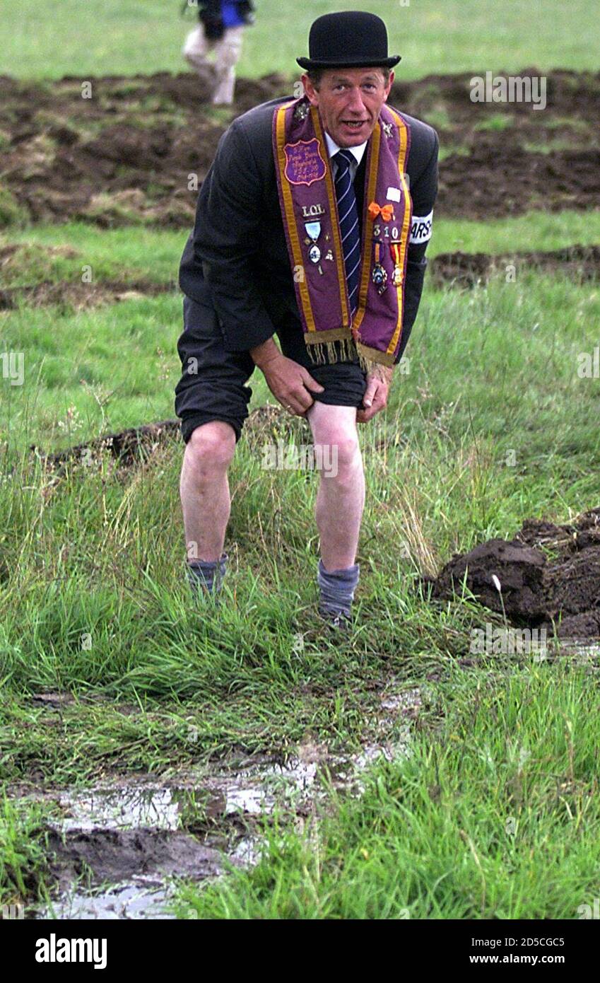 An Orangeman rolls up his trouser legs in the muddy field of Drumcree church in Portadown July 3. The Orange order march from the church down the Garvaghy road this year has been banned by the Parades Commission in Northern Ireland.  DC/KC Stock Photo