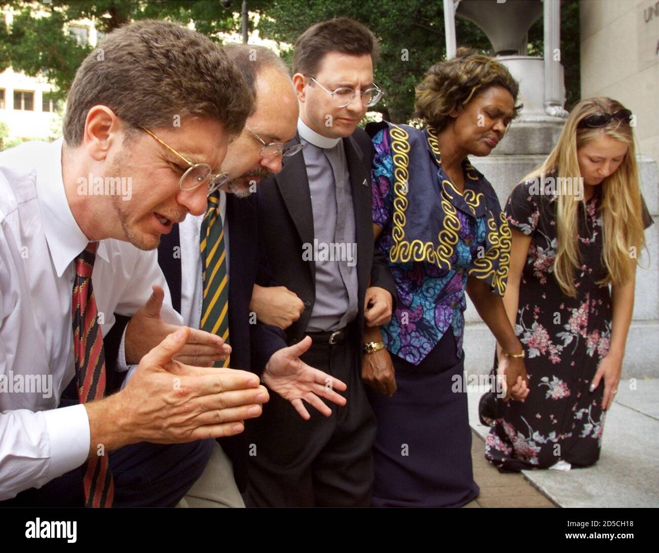 Members of the Christian Defense Coalition pray in front of the Justice Department in Washington, D.C. September 1. The group first held a press conference to call for an independent investigation of the of the Clinton administration's handling of the 1993 destruction of the Branch Davidian compound in Waco, Texas. From left to right are Randall Terry, Operation Rescue; Rev. Patrick Mahoney, Christian Defense Coalition; Rev. Robert Schenk, National Clergy Council; Rev. Imagene Stewart, African-American Women's Clergy Association; and Brandi Swindell from the American Center for Law and Justice Stock Photo