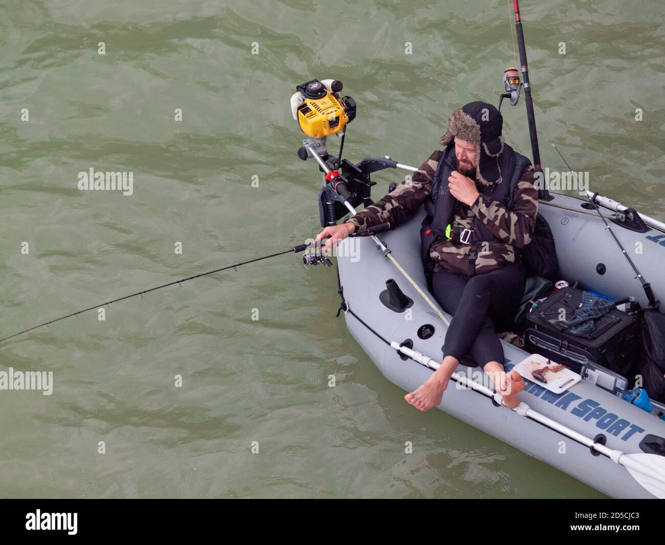 Man fishing from inflatable boat on river Stock Photo - Alamy