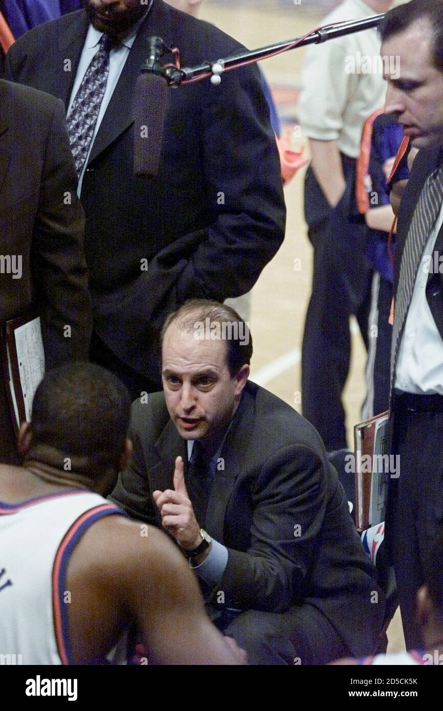 New York Knicks' coach Jeff Van Gundy gives his instructions to forward  Larry Johnson (L) in a team huddle monitored by a boom mike during a time  out in their NBA game