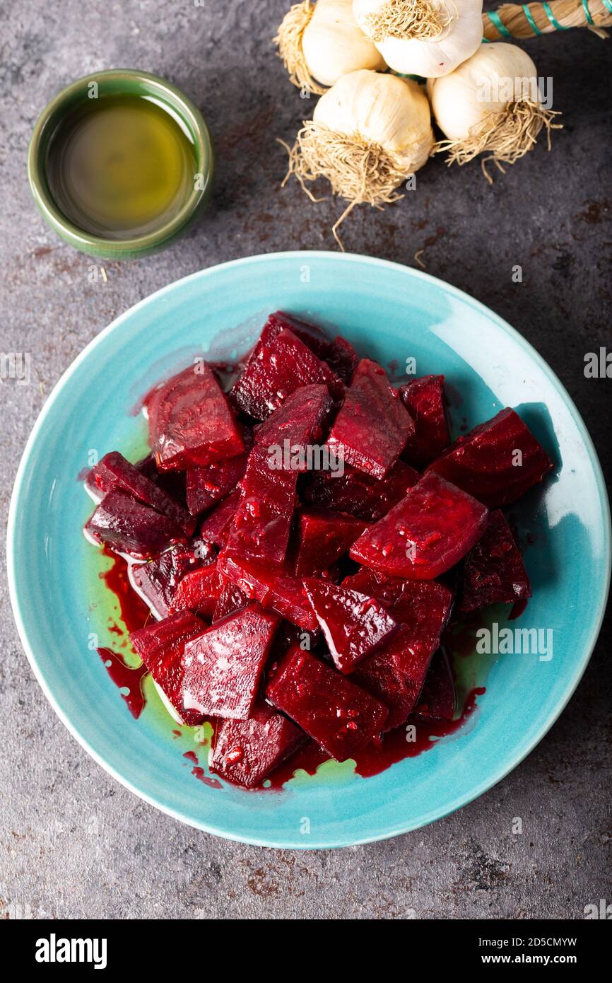 Beetroot salad with garlic and olive oil sauce in dish on dark