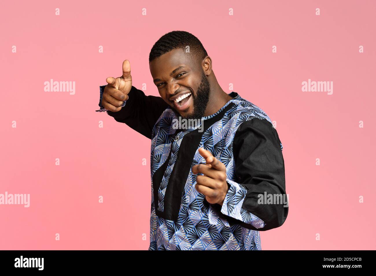 Handsome black young man in traditional costume indicating to camera Stock Photo