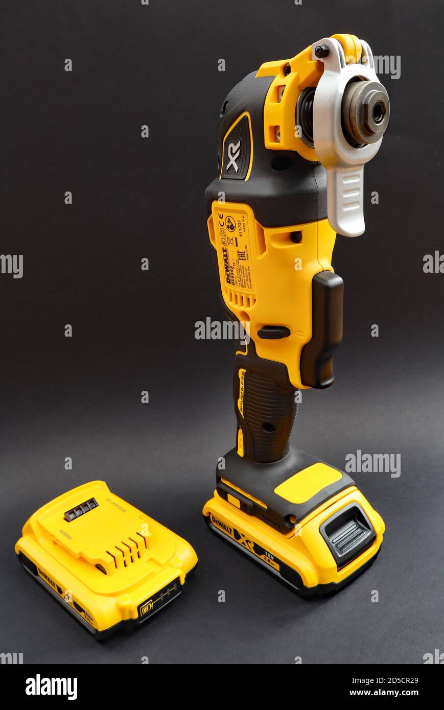 OTTERY ST MARY DEVON FEBRUARY 6TH 2020 Dewalt Cordless Multi Tool stands upright on its battery on a black background. A spare battery is by the s Stock Photo Alamy