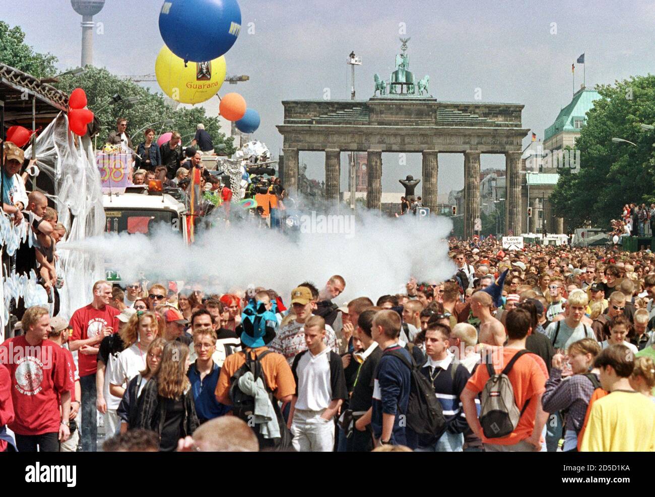 Revellers at Berlin's famous landmark, the Brandenburg Gate, watch floats make their way through the dense masses during the German capital's annual "Love Parade" techno music fest July 11. Over a million people are expected to attend this year's tenth anniversary street parade with the motto "One World, One Future". Stock Photo