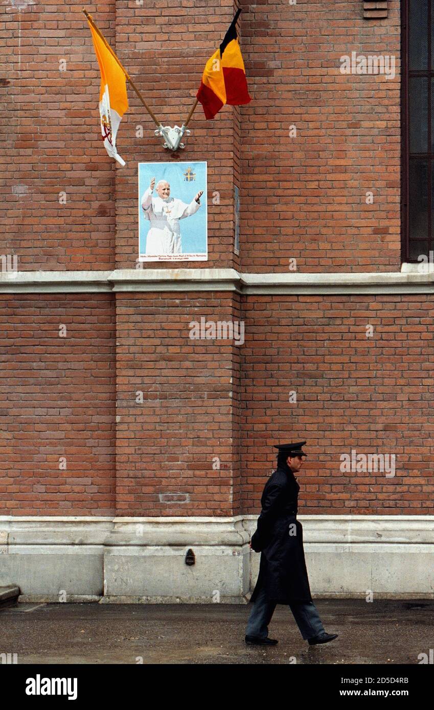 A guard walks outside St. Joseph's Roman Catholic cathedral in Bucharest May 6, ahead of Pope John Paul's visit to Romania, the first by a pontiff to a mainly Orthodox country. The cathedral, with a portrait of John Paul plastered on its wall, will be the site of a mass for eastern rite, or Greek-Catholics. The pope's visit, the first ever to a mainly Orthodox country, is intended to improve relations between the Catholic and Orthodox church, split since the 11th century.  BC/JDP Stock Photo