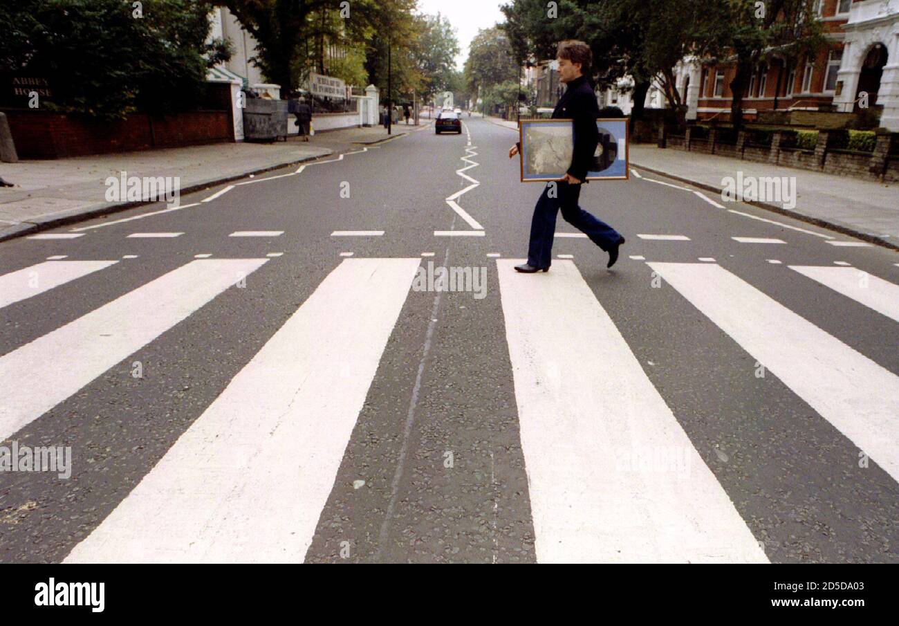 Self-proclaimed Number One Beatles fan Alan Harrington, from St Albans,  walks across Abbey Road carrying a signed copy of "Let It Be" September 26.  Twenty-five years ago today the Beatles released their