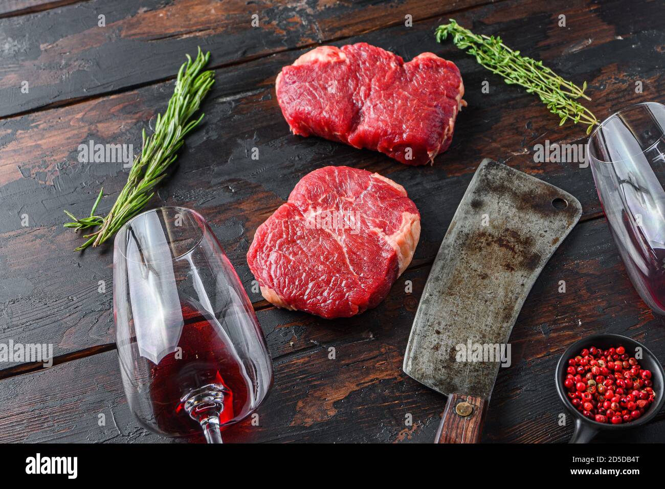 Raw rump steaks with american butcher cleaver and two glass of red wine ...