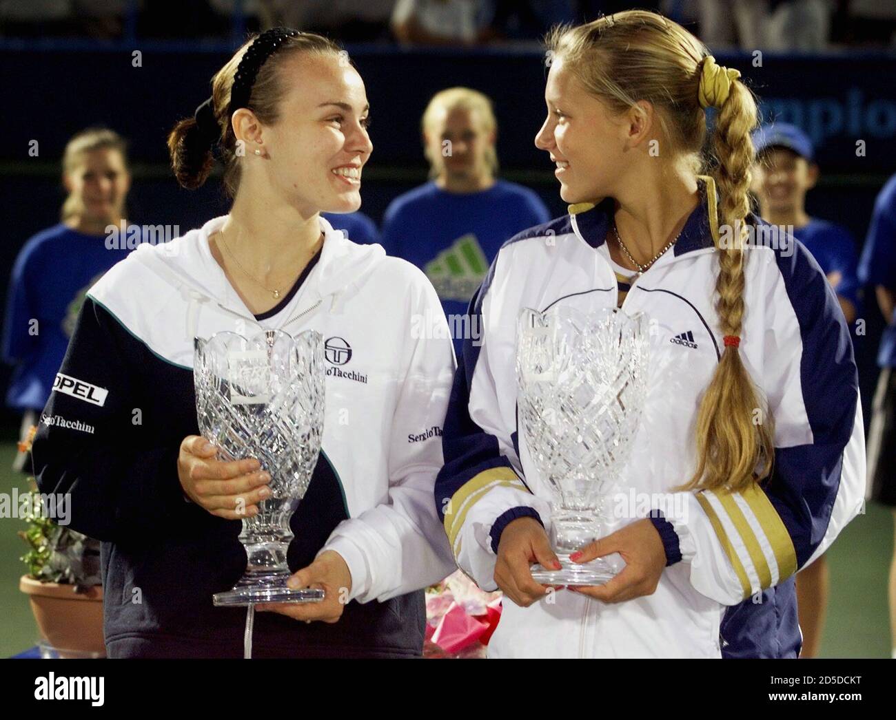 Martina Hingis (L) of Switzerland and her doubles partner Ana Kournikova of  Russia chat while holding their trophies after their victory against Mary  Jo Fernandez of the USA and Jana Novotna of