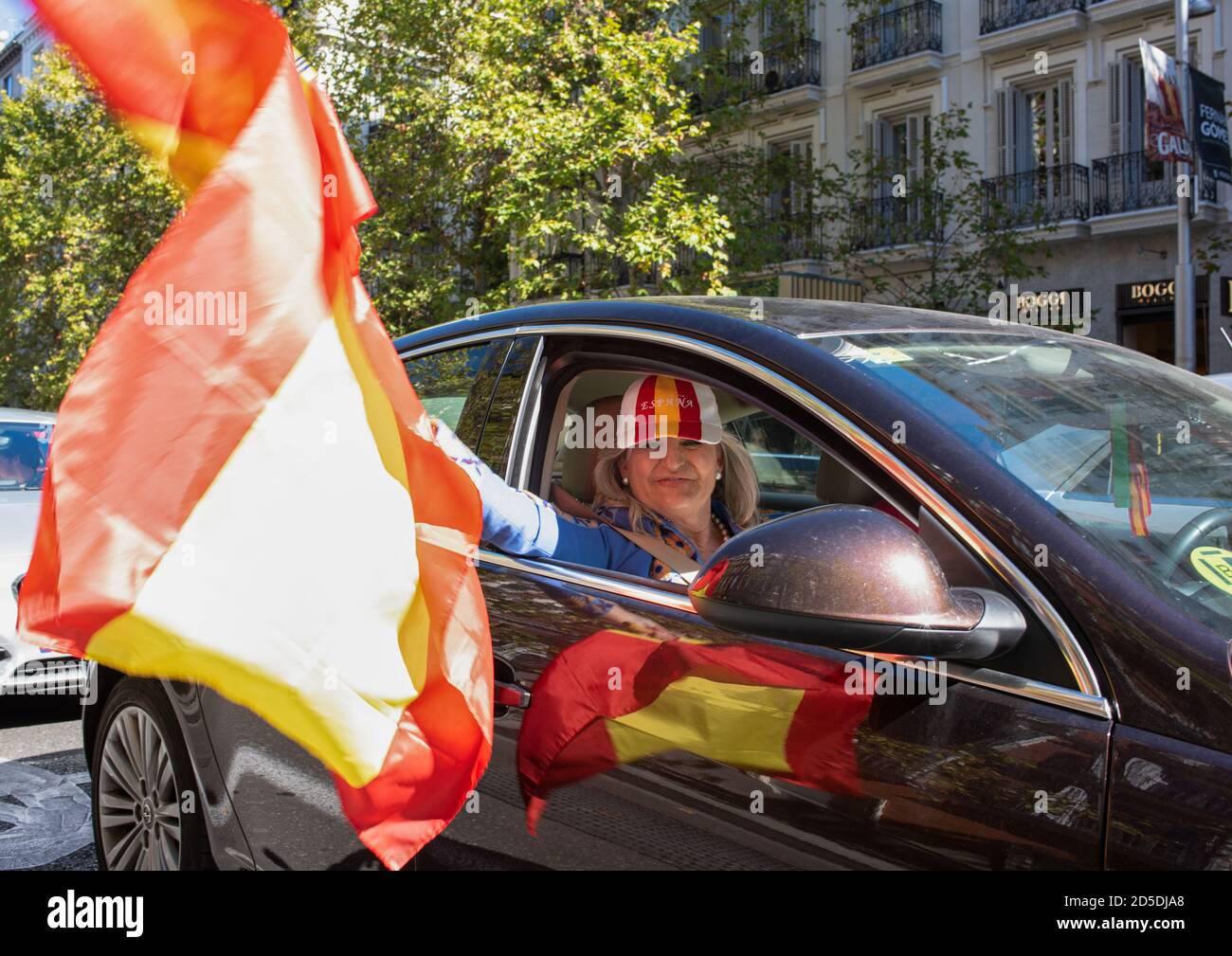 Madrid, Spain, 12th oct 2020. Woman posing with flag as she attends a car parade protest against Spanish government's handling of the COVID-19 crisis. Stock Photo