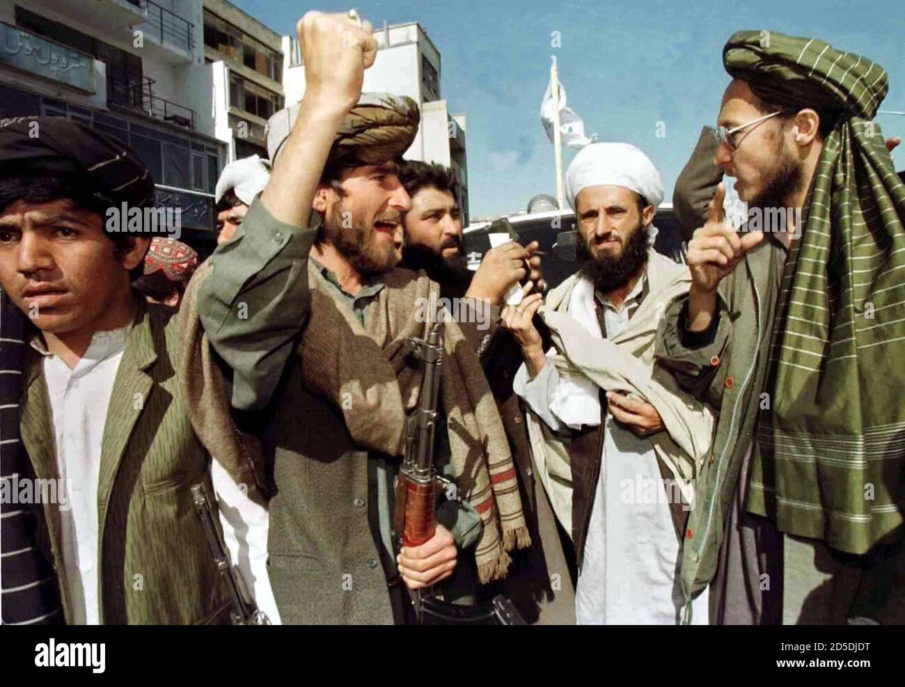 Afghan Taliban Islamic militia fighters cheer Mullah Rahman (2nd from R) as he addresses thousands of demonstrators in Kabul, October 17. The protest was against what the Taliban calls interference [of Iran, Russia and India in Afghan affairs.] Stock Photo