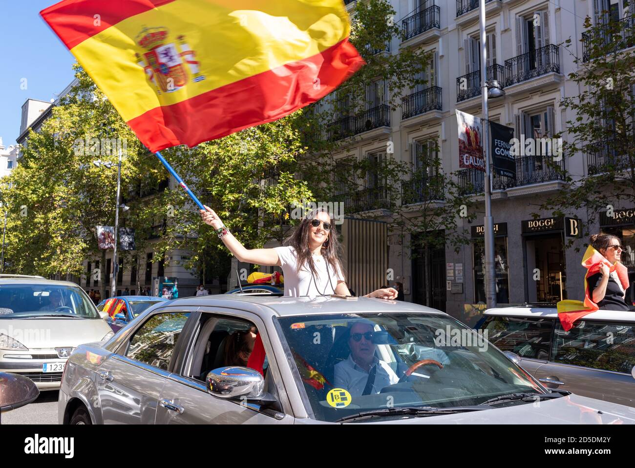 Madrid, Spain, 12th oct 2020. Girl waving flag as she attends a car parade protest against Spanish government's handling of the COVID-19 crisis. Stock Photo